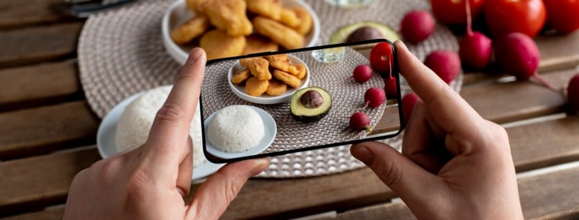 telefono che fa una foto ad un piatto con riso, pomodori e nuggets